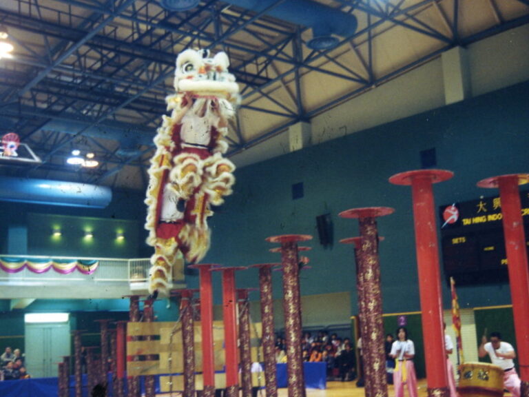 Lion jumps from one pole to another in Lion dance performance in Hong Kong