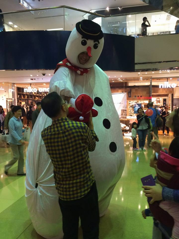 giant snowman character shaking hand with baby in hong kong