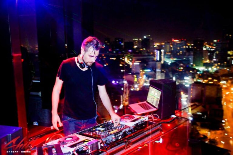 DJ Pure MB making music with night view of Hong Kong