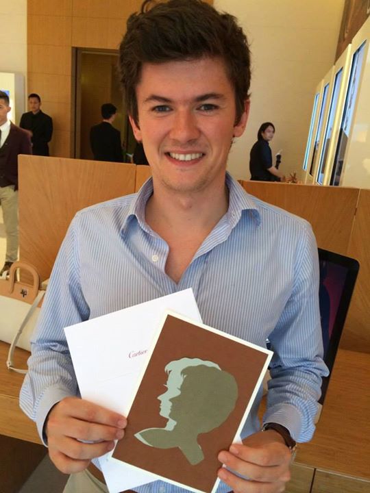 Male client in blue shirt holding portrait cut out at Cartier event
