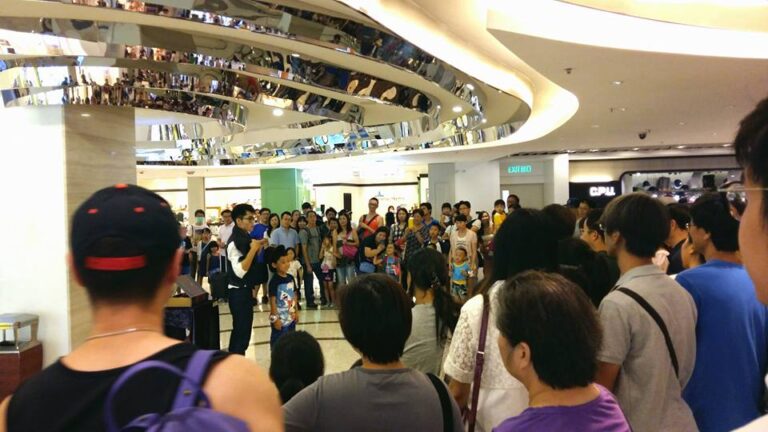 Hong Kong roving magician performing magic with a big audience at a Hong Kong shopping mall