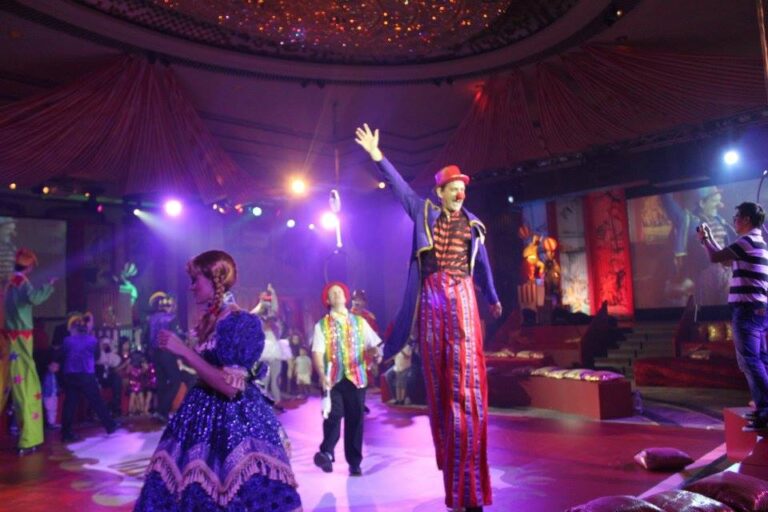 Stiltwalker and juggler and pretty girl in parade in the Hyat Hong Kong ballroom