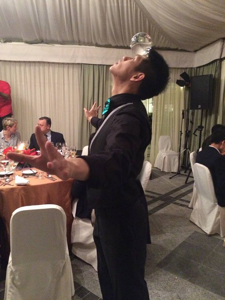 Roving juggler in Hong Kong holding a crystal ball on his head with out using his hands at a corporate cocktail party