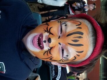 A little kid in a school fair got a cute lion face paint form a Hong Kong face painter.