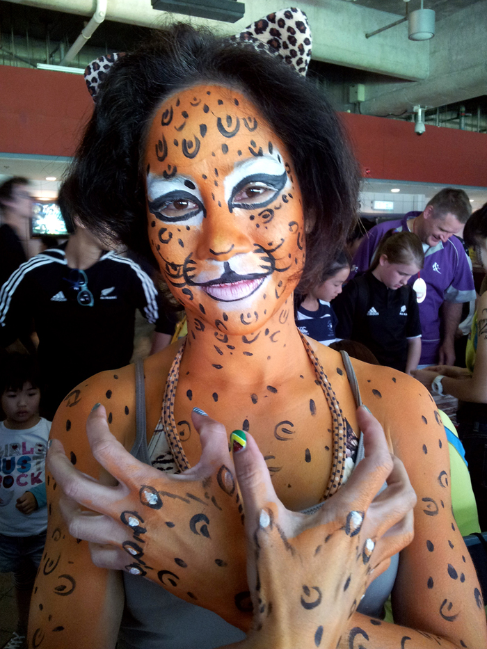 A Hong Kong talented face painter draw a half body leopard paint for a lady at a corporate function.