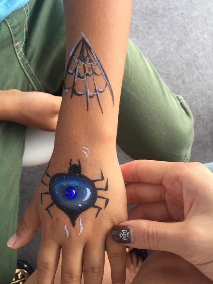 The kid form a Halloween corporate function , had a scary spider and net paint on hand and arm by a Hong Kong face painter