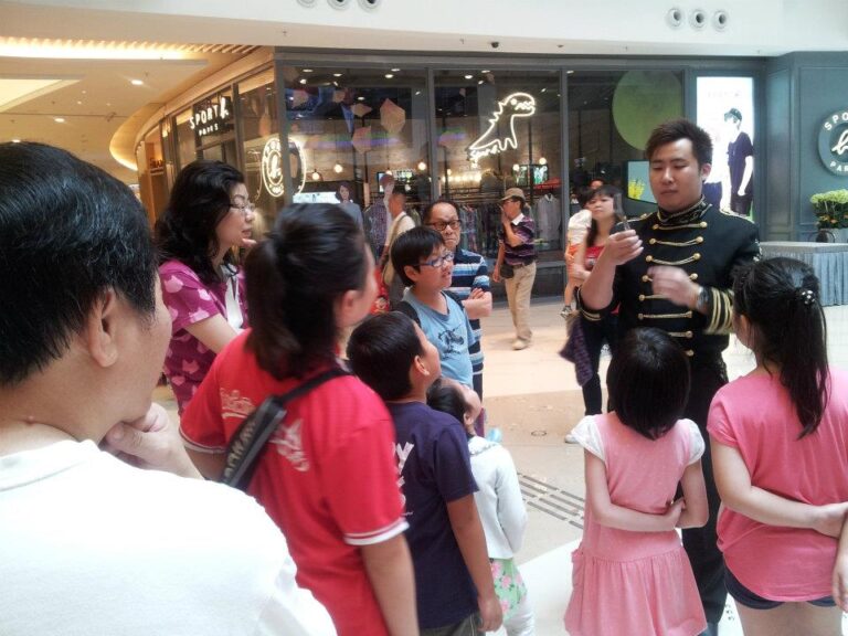 Roving Magician performing spoon bending magic to children at Hong Kong Popcorn Mall store opening event