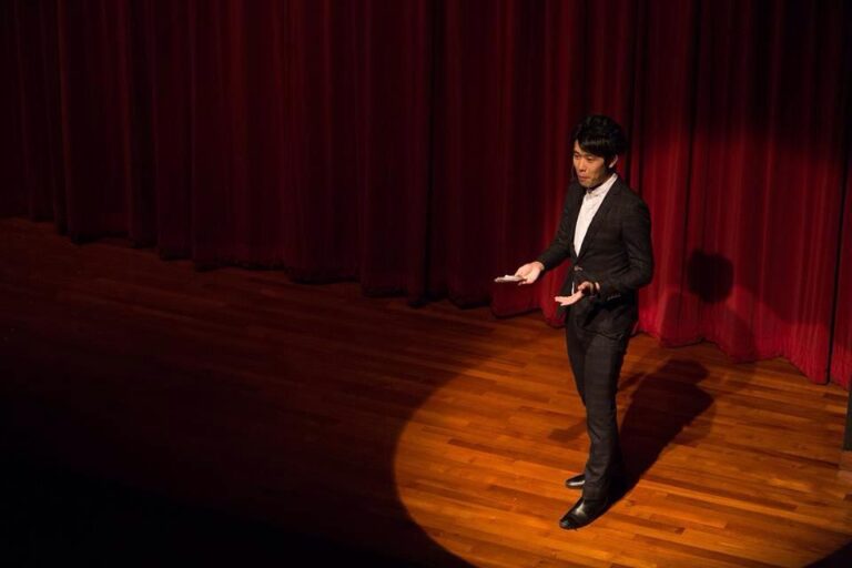 Hong Kong Magician performing stage magic with a spotlight on him at corporate annual dinner