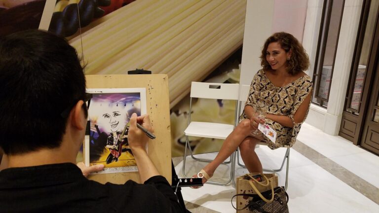 Lady getting her pic drawn by caricaturist