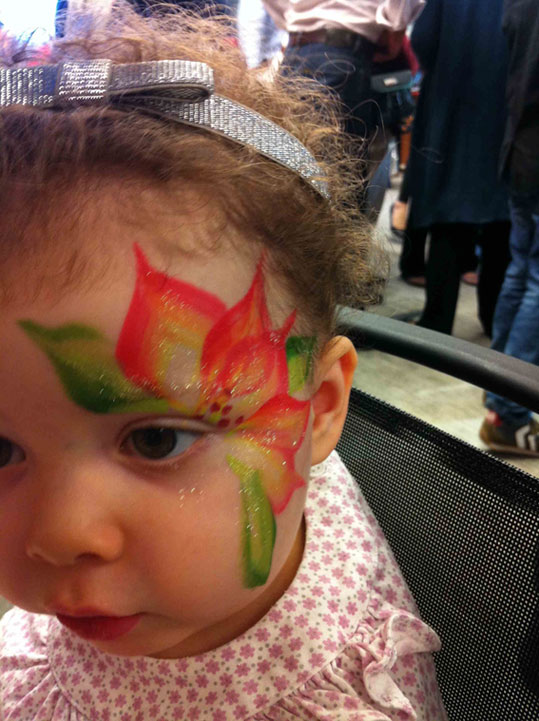 A little girl got a Poinsettia face paint form a professional face painter in HK at a Xmas corporate function.