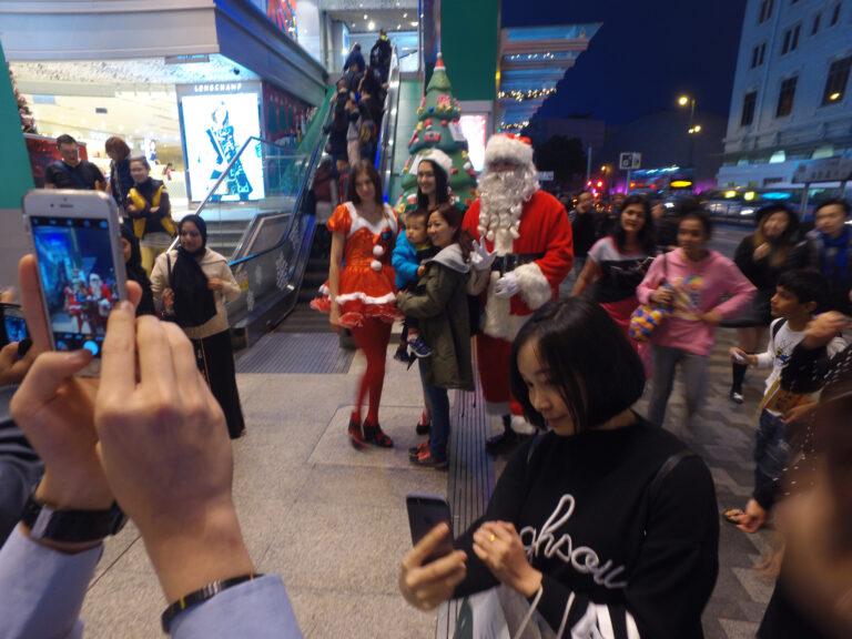 Hong Kong Xmas performers in Santa ,Santa girl and Elf costumes taking pictures with the guests at Sogo Christmas function.