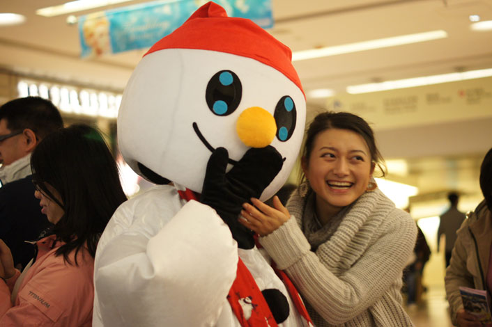 Snowman Xmas mascot laughing in SOGO shopping center with a shopper