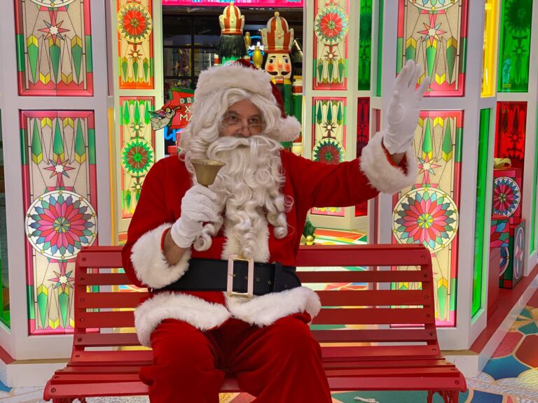 santa in red costume waving at guests