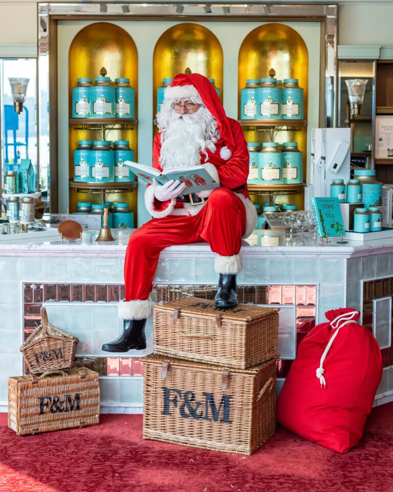 Hugh Santa sitting on counter reading a book