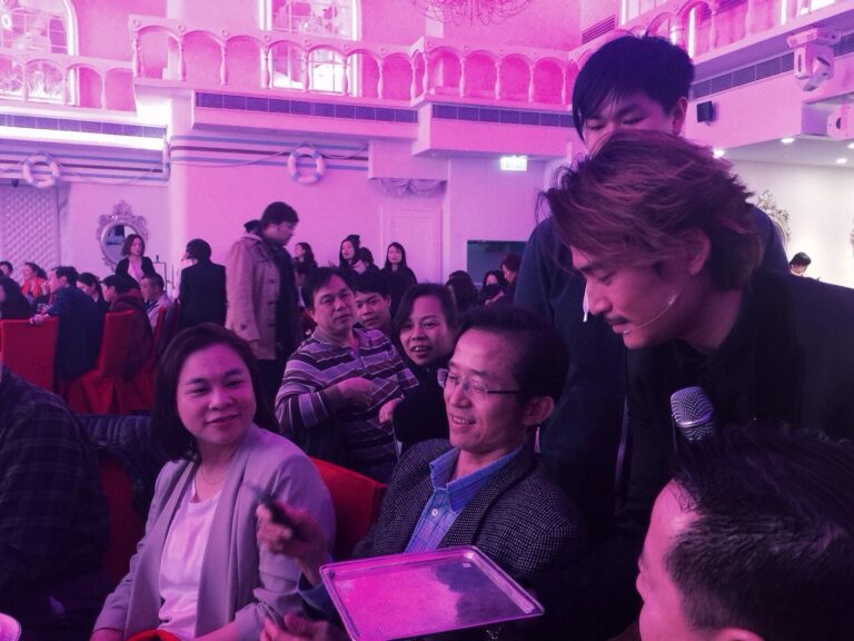 Hong Kong magician is is borrowing a mobile form the gentlemen to finish his stage magic at a corporate annual dinner