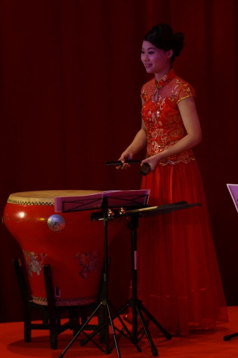 Chinese music musician in Hong Kong playing traditional instrument Bamboo Castanets behind the Chinese drum on the stage