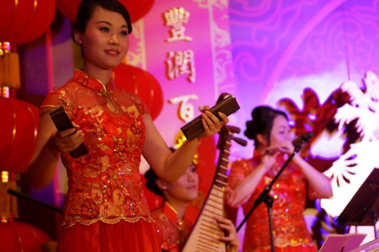 Three Hong Kong Chinese music musicians playing Chinese traditional instrument Bamboo Castanet , Pipa and Xiao at a New year event