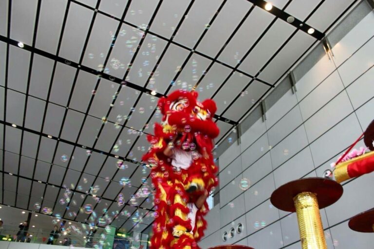 Hong Kong Dancer performing stage bubbles Lion Dance with a red lion costume at a shopping mall Chinese new year event