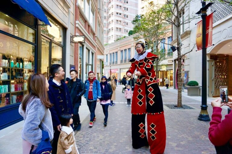 performance on the streets in stilt costume interacting with guests
