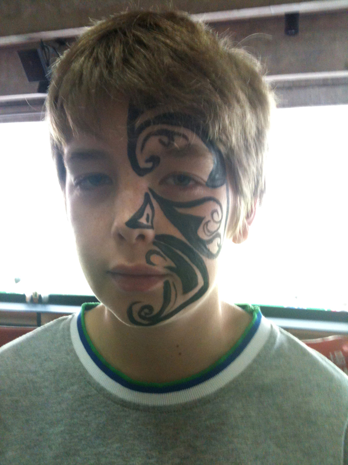 Hong Kong professional face painter paint a tattoo style face paint for boys at a corporate Xmas event.