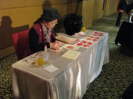 artist with table in costume chinese traditoal craft work