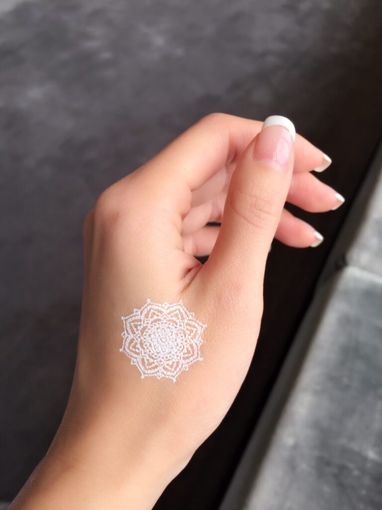 A white temporary henna tattoos on hand