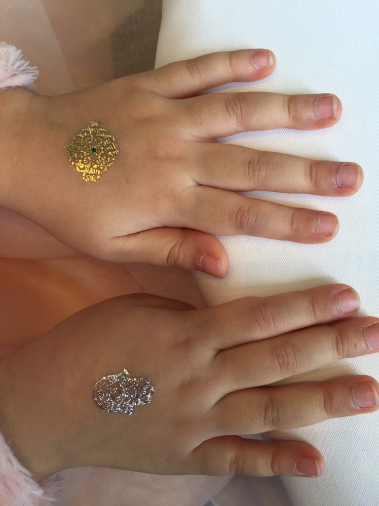 Two Sliver and gold henna temporary tattoos on hands