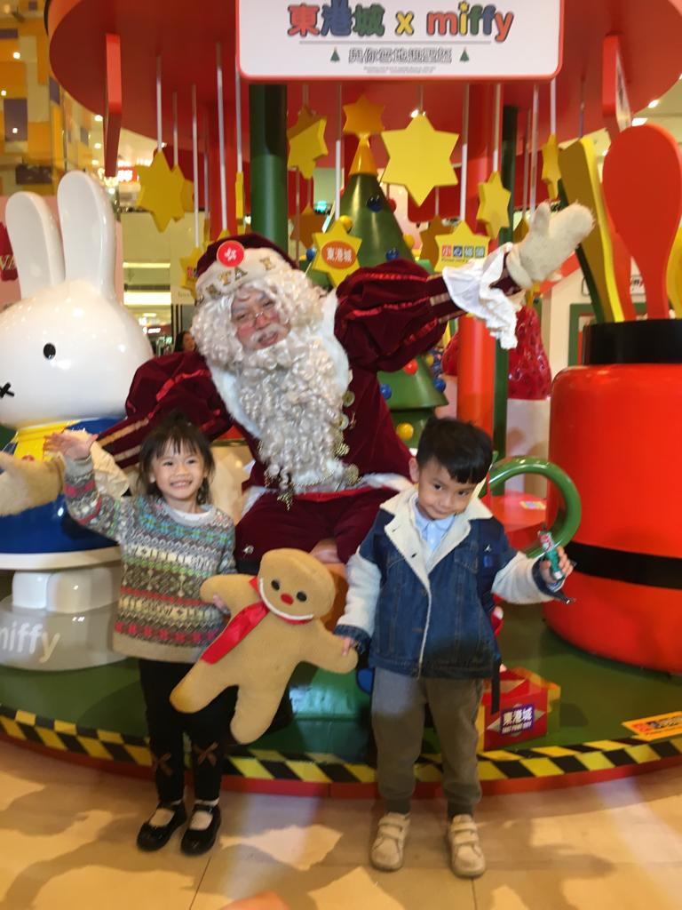 Kid stands in front of Santa mario at an eventy