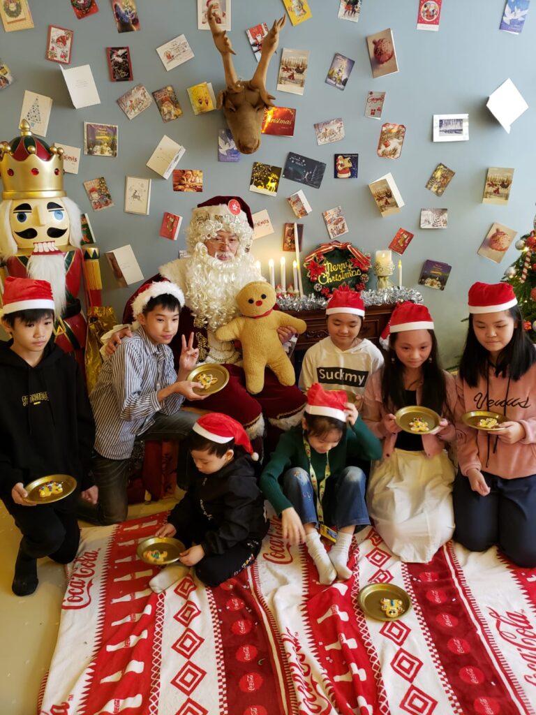 Mario Santa sitting with a bunch of kids at an event in hk for kids during Christmas time in Hong Kong shopping mall event