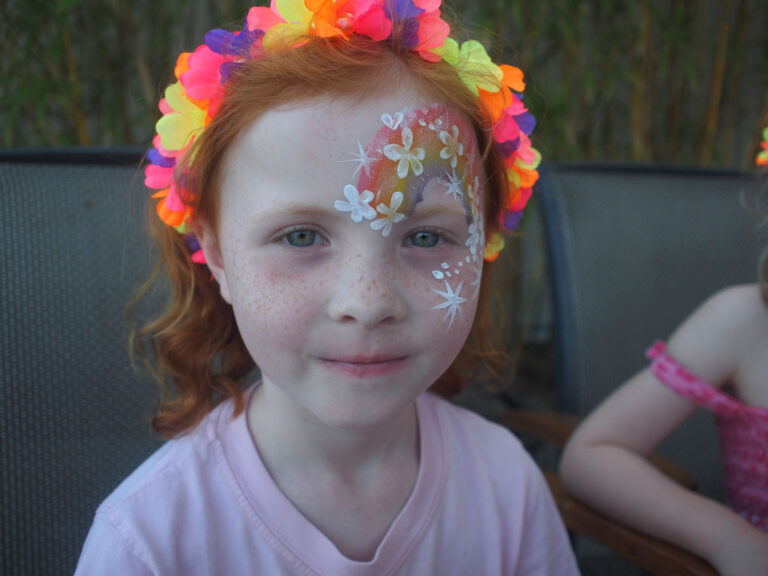 A HK face painter draw a rainbow face paint for a rainbow themed summer party