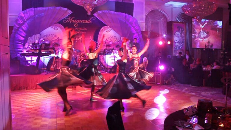 four cancan dancers spinning in circle on dance floor at an event