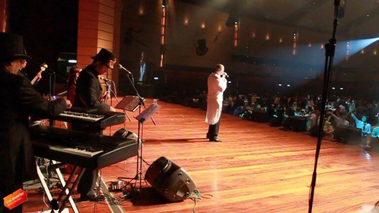 Hong Kong singer performing with a live band on stage at a Annual dinner