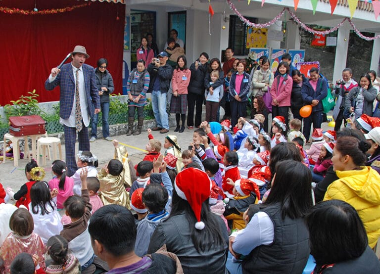 The juggler asking for a volunteer and a lot of the audience putting their hands at a Hong Kong Christmas event
