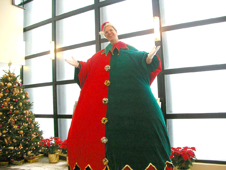 fat brothers giant stilt walker in elf costume in front of xmas tree in repulse bay zoomed in image