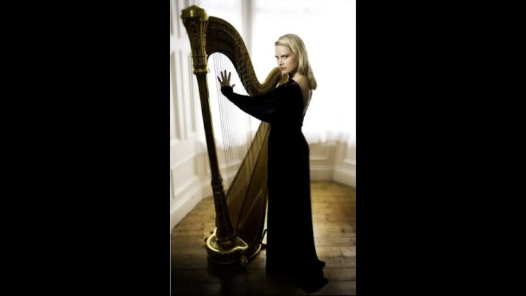 A HK harpist wearing a black dress posing next with the harp for a wedding