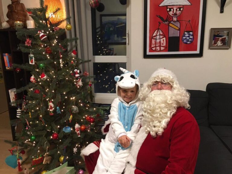 santa pete having a child sit on his lap during santa home visit