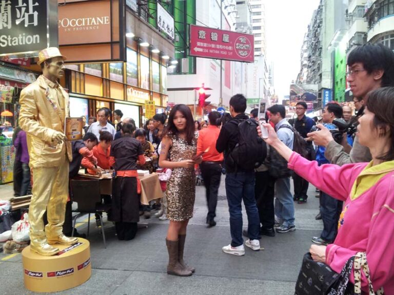 Promotion girl with Golden statue standing on box