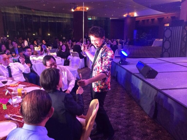 Roving magician in Hong Kong performing roving magic to CEO with wine at annual dinner