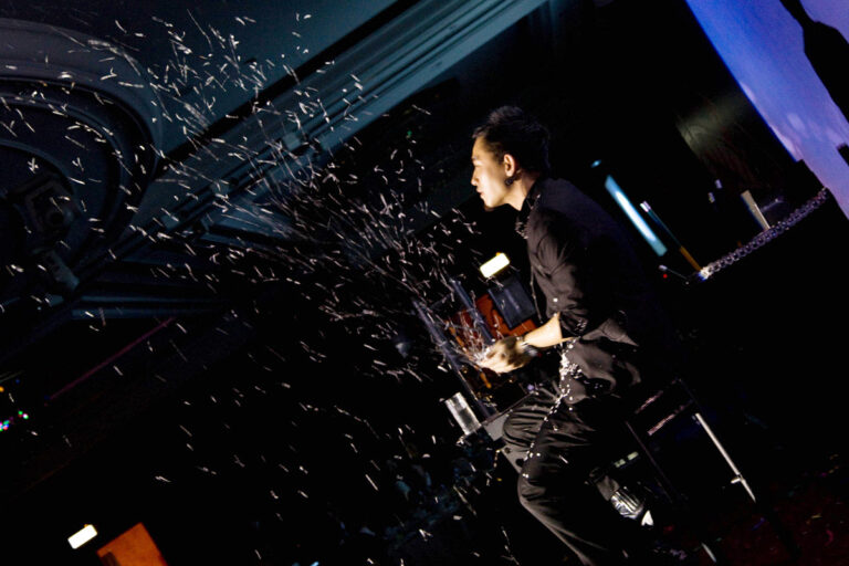 Hong Kong Magic sitting on the chair  performing stage magic snow storm at a corporate annual dinner
