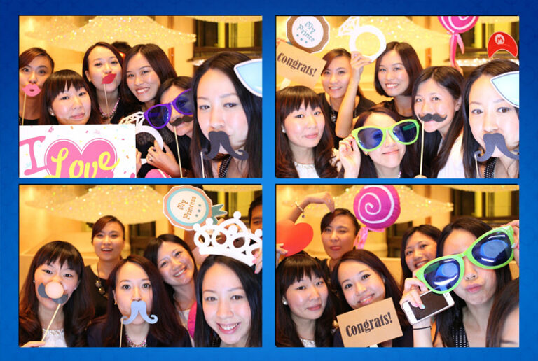 ladies wearing funny props taking pictures at photobooth stall