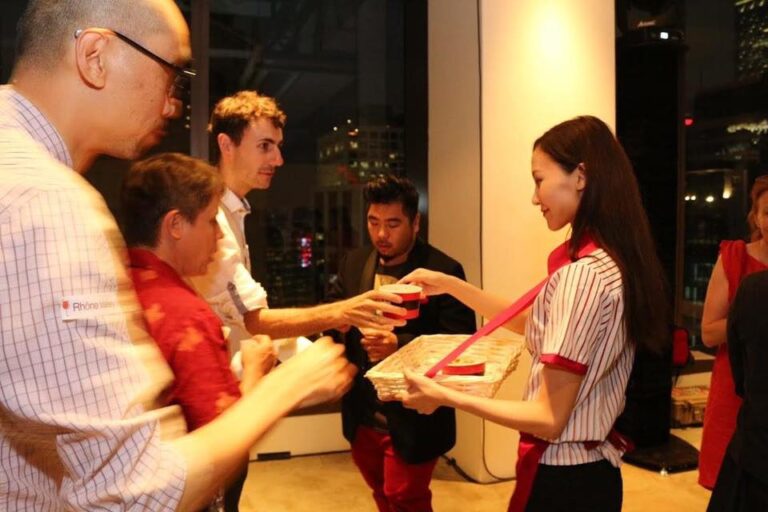 Model serving pop corn in 8oz containers at an event with a cinema themed event, guests happily taking the pop corn