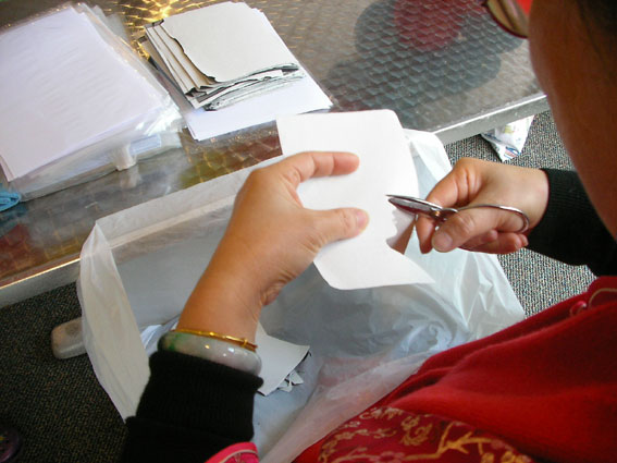 Portrait cutout artist with scissors demonstrating her wares
