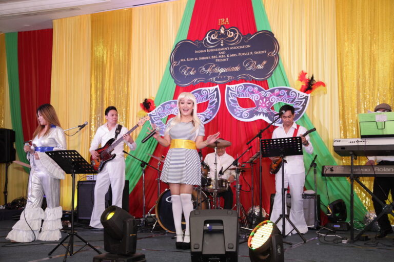 Band dressed in Abba clothing performing in hotel ballroom