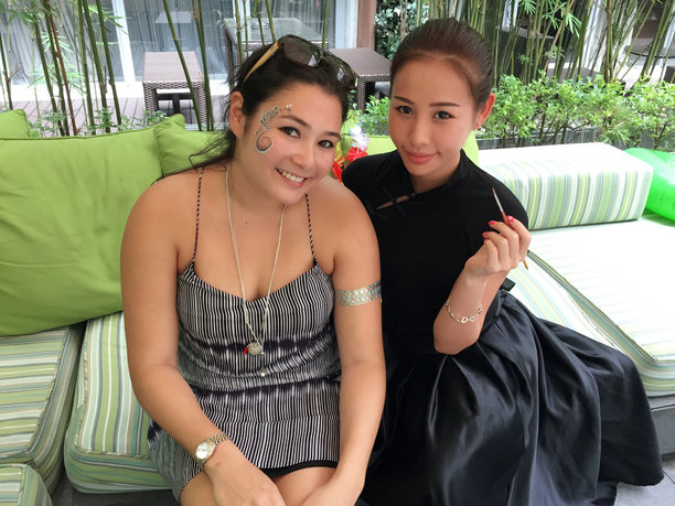 Face painter in Hong Kong taking picture with her client after she finished a beautiful face painting at a event