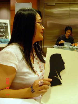 A Hong Kong lady showing off her portrait cut out at a corporate event
