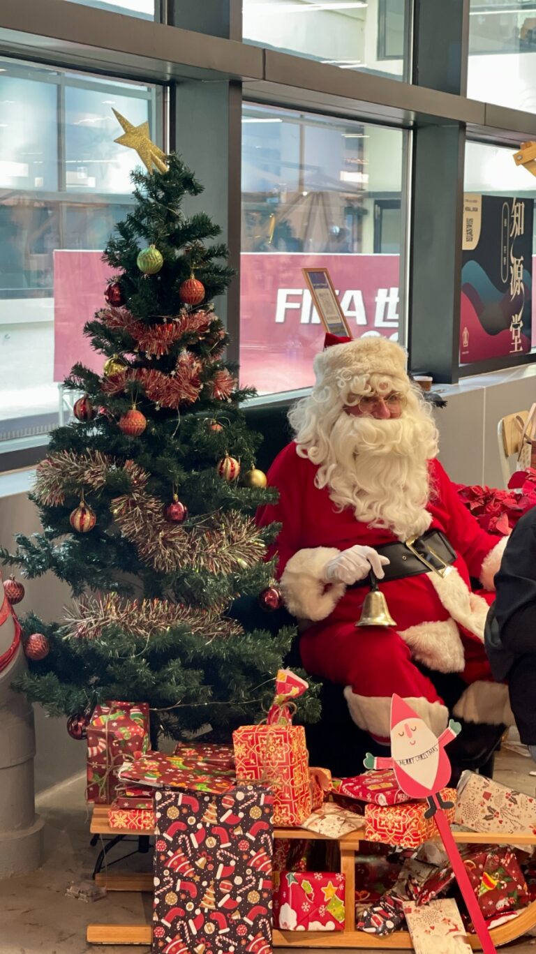 Santa sitting in front of a Christmas tree in Central market Hong kong