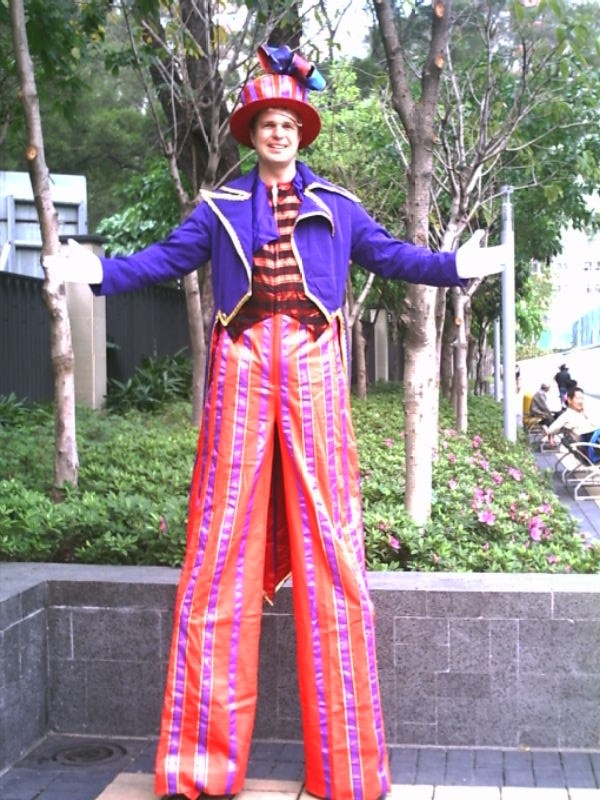 Hong Kong Stilt-walker wearing a purple and pink costume at a school event