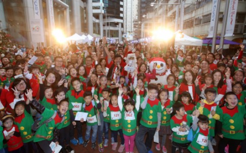 Hong Kong performer dress as Santa Claus and snow man with 400 participants who dress as Elf taking picture at Swire Properties three-day Christmas street fair in Tai Koo Place, Quarry Bay.