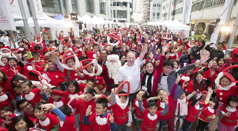 Group photo of large group of Santa helpers with santa in the middle