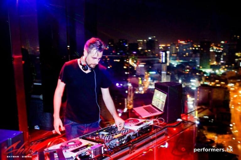 DJ Pure MB making music with night view of Hong Kong